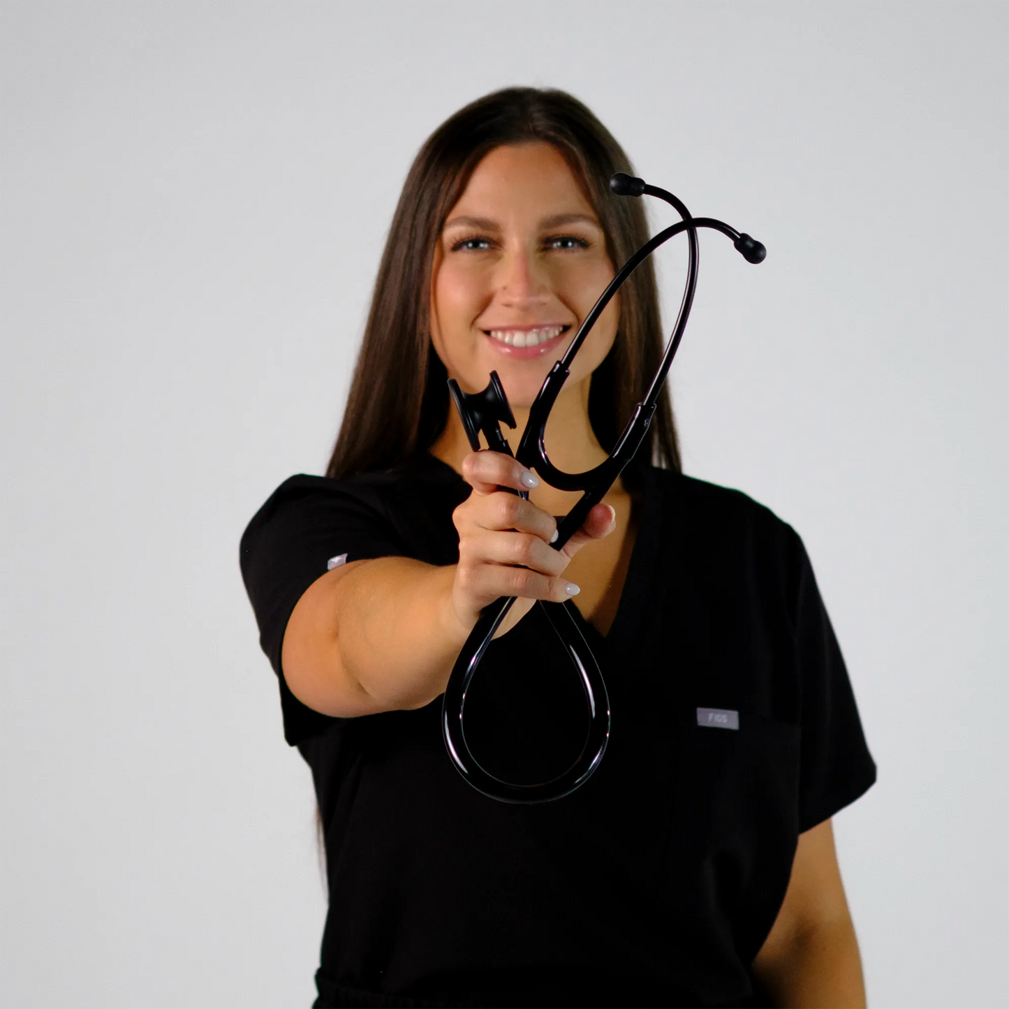 Model holding a black cardiology stethoscope