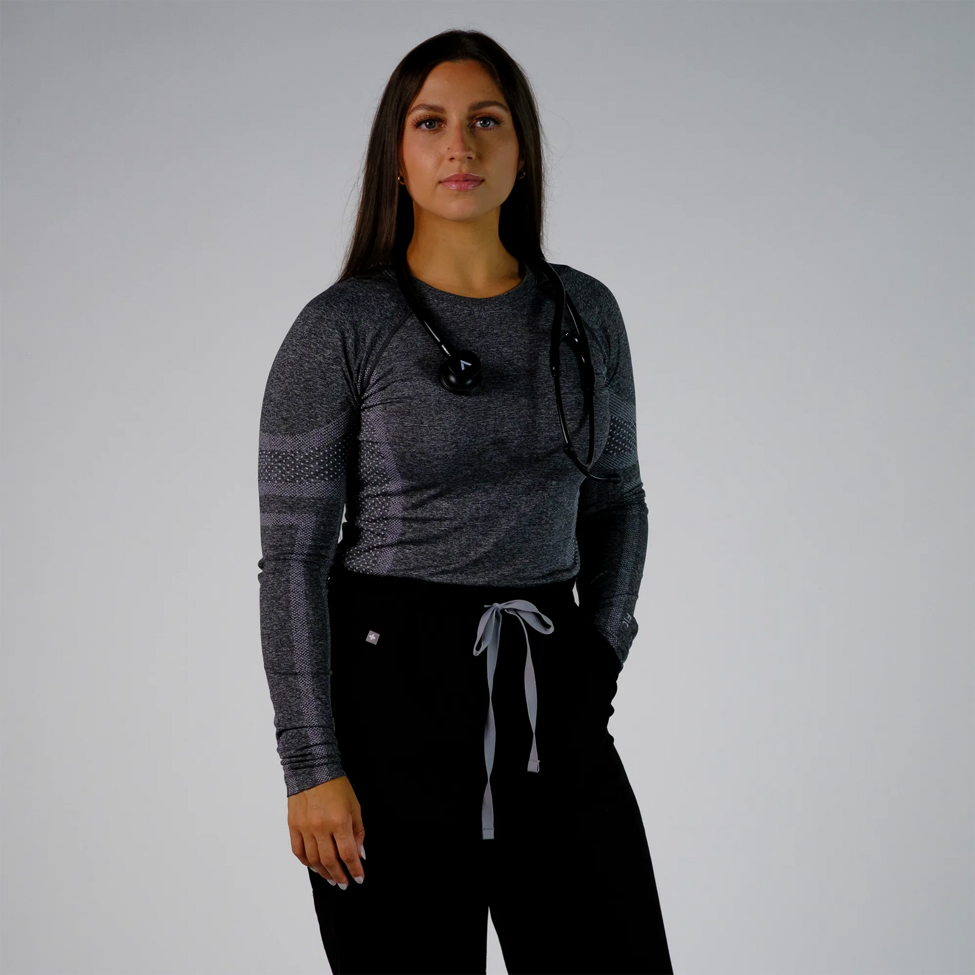 Model wearing a black cardiology stethoscope