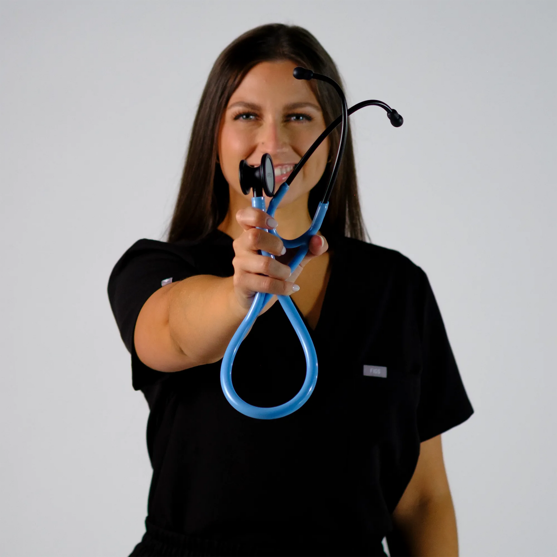 a model smiling with a blue cardiology stethoscope