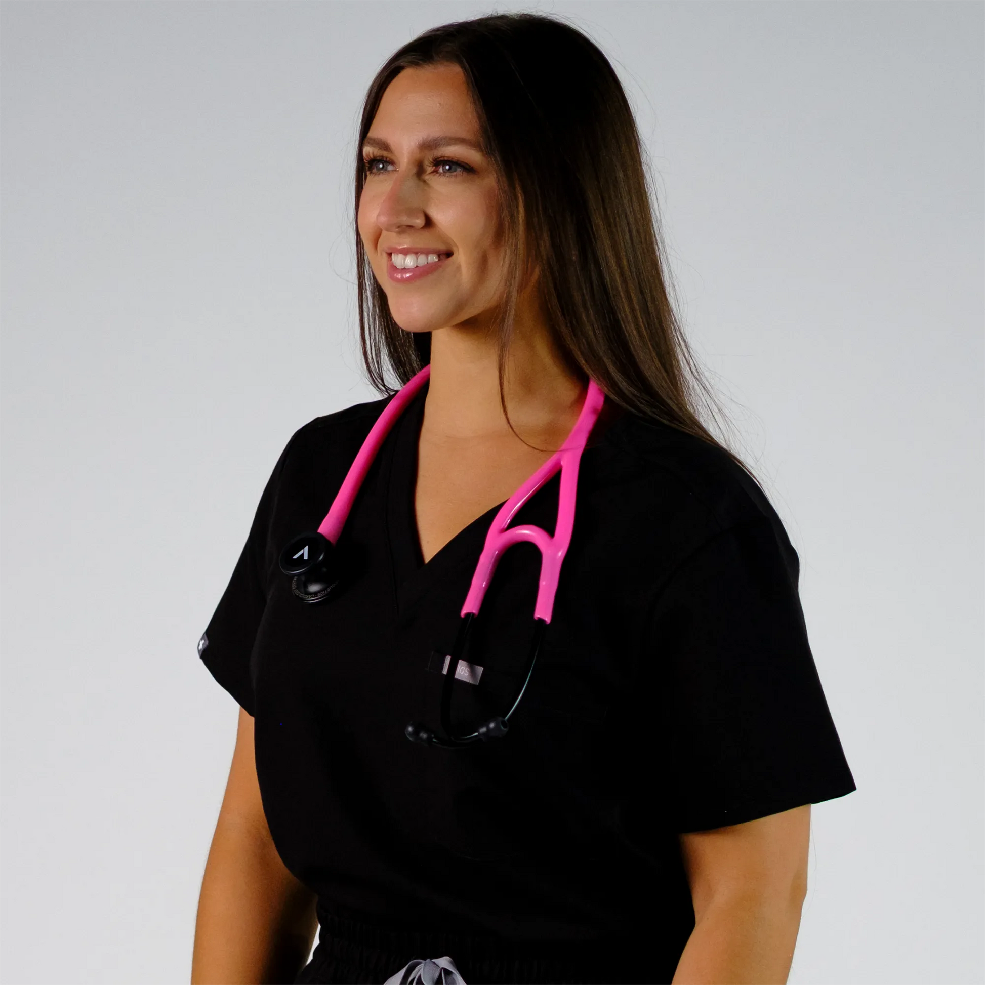 model smiling with a pink cardiology stethoscope