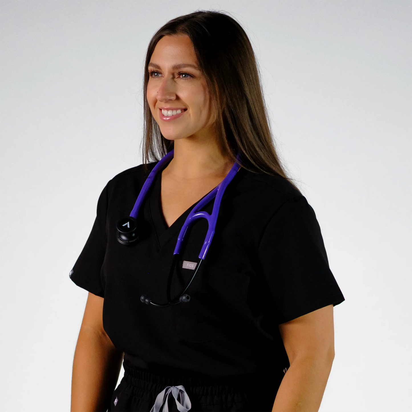 model smiling with purple cardiology stethoscope