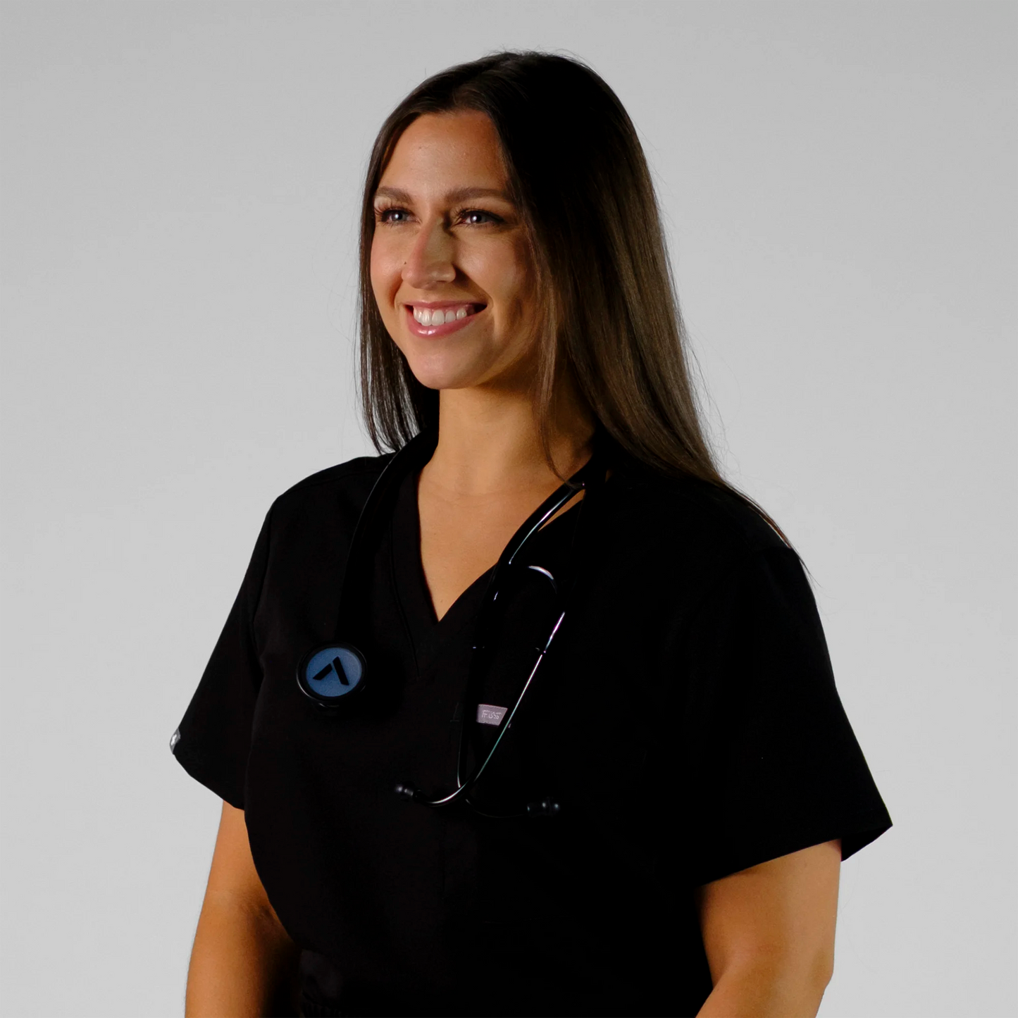 model smiling with a cardiology stethoscope