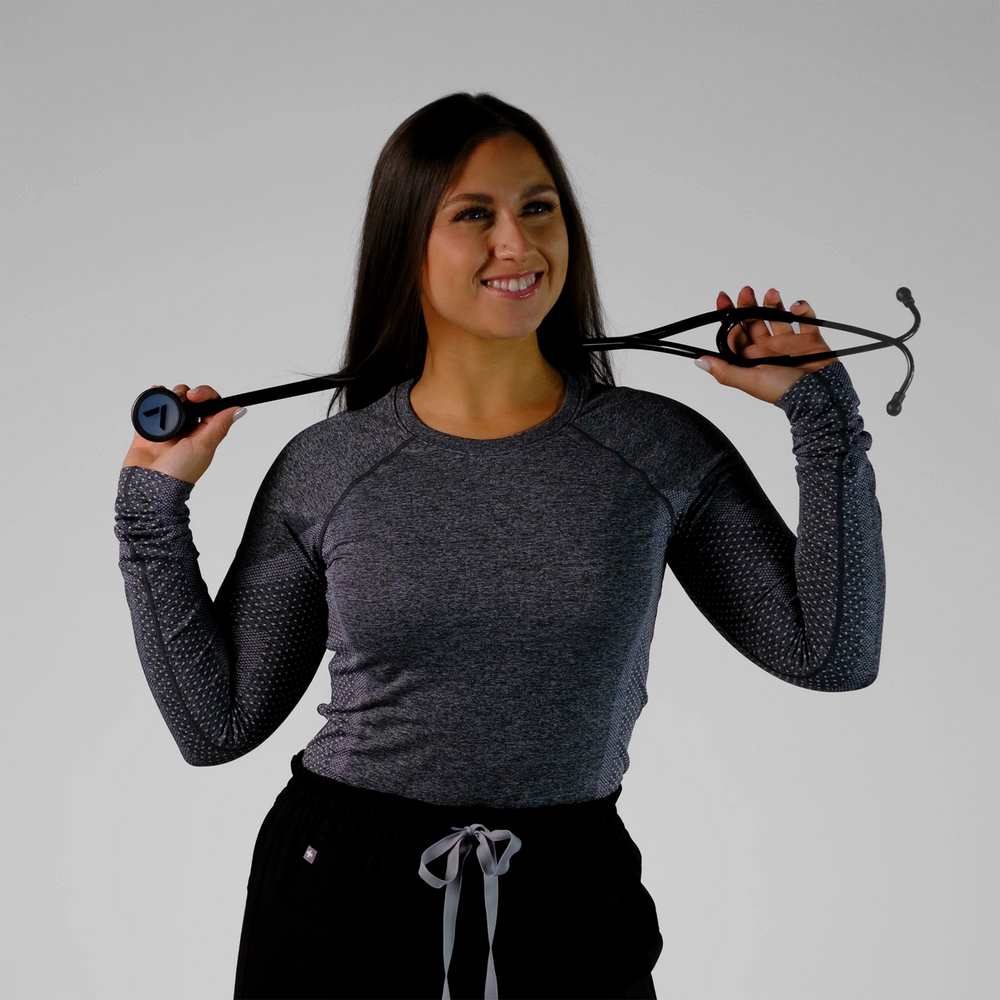 model holding a black cardiology stethoscope