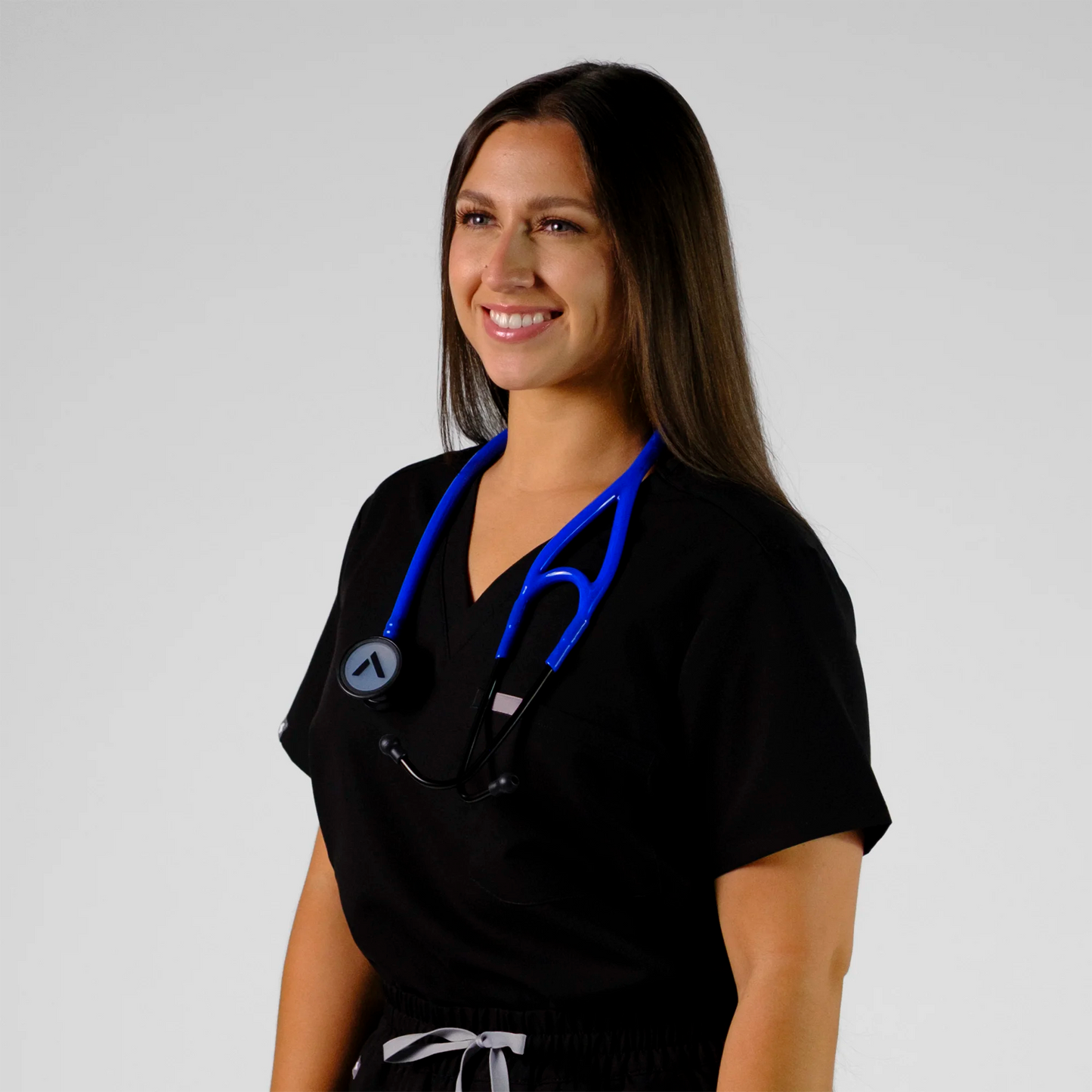 model smiling wearing a blue cardiology stethoscope