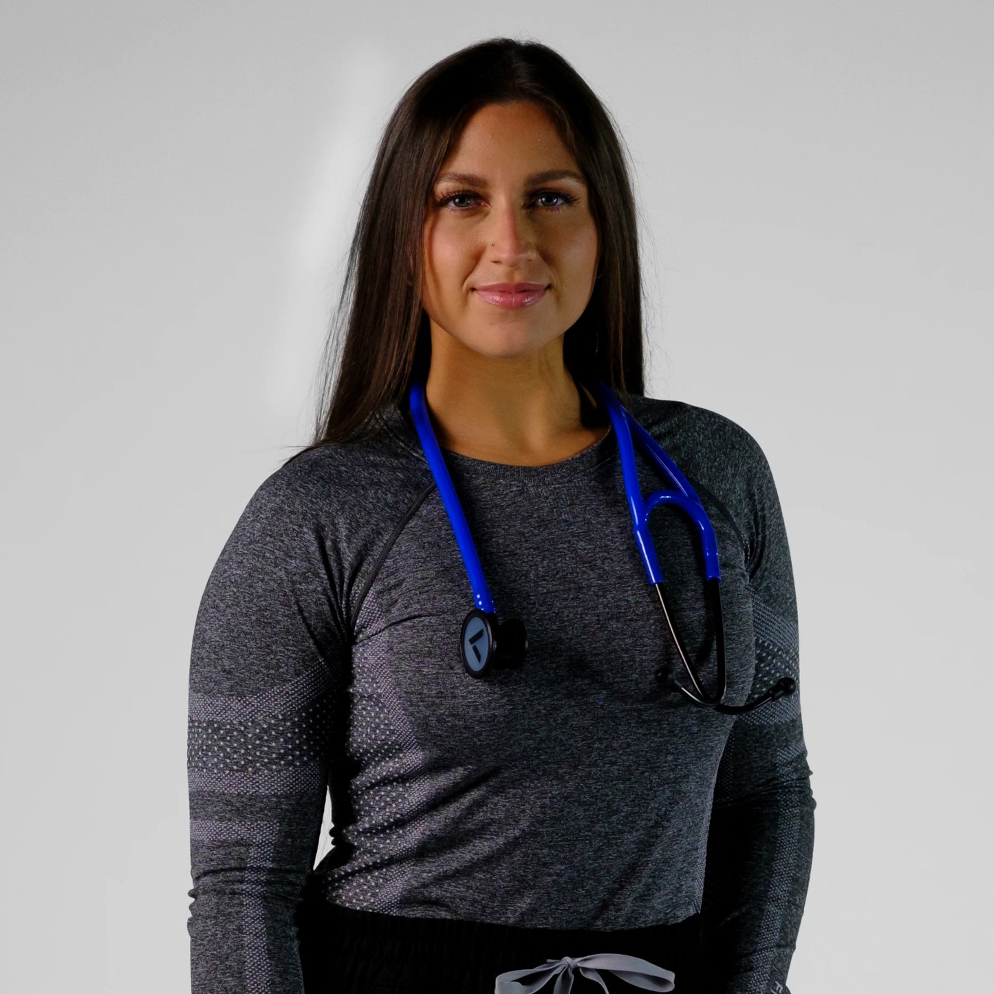 model standing wearing a blue cardiology stethoscope