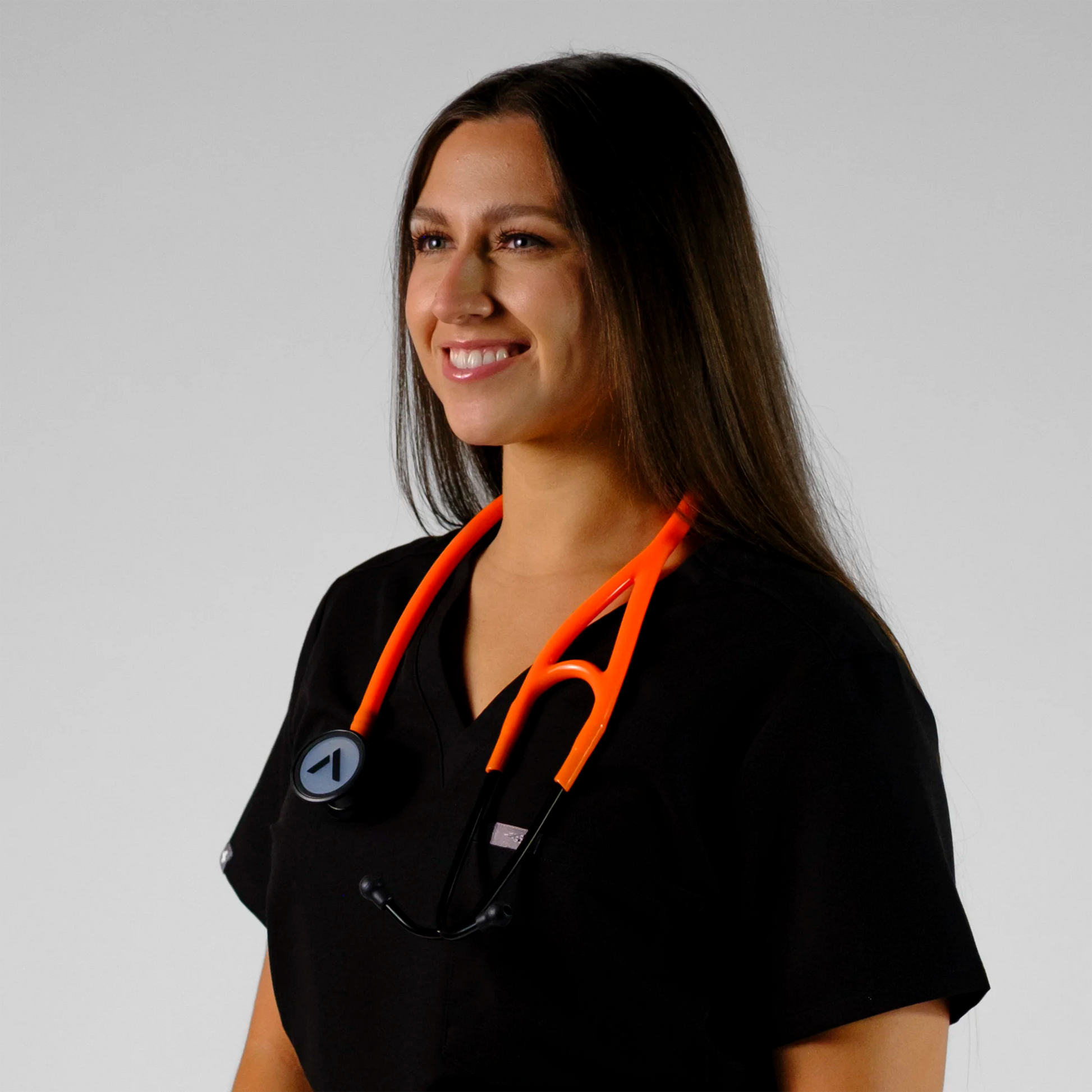 model smiling with an orange cardiology stethoscope