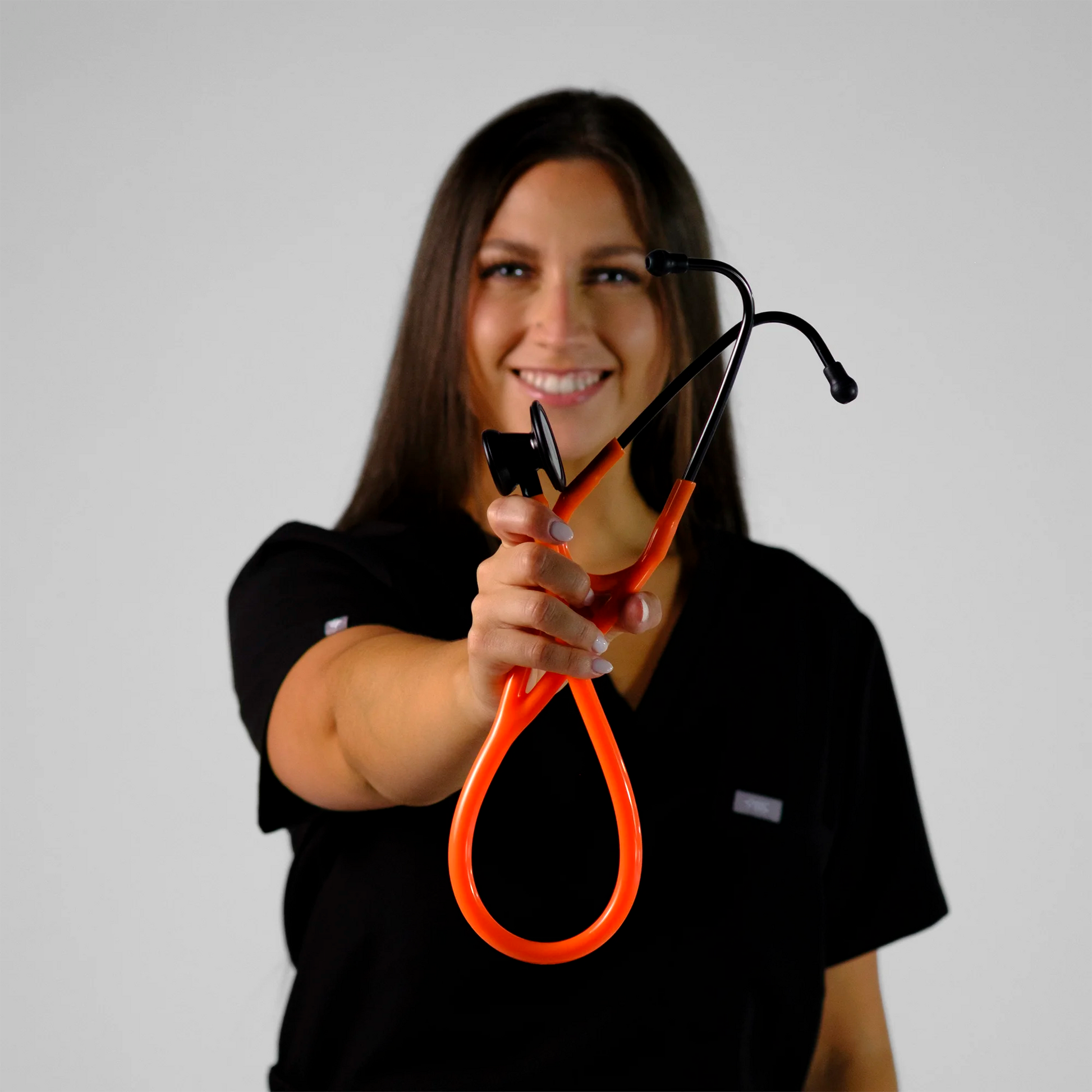 model holding an orange cardiology stethoscope