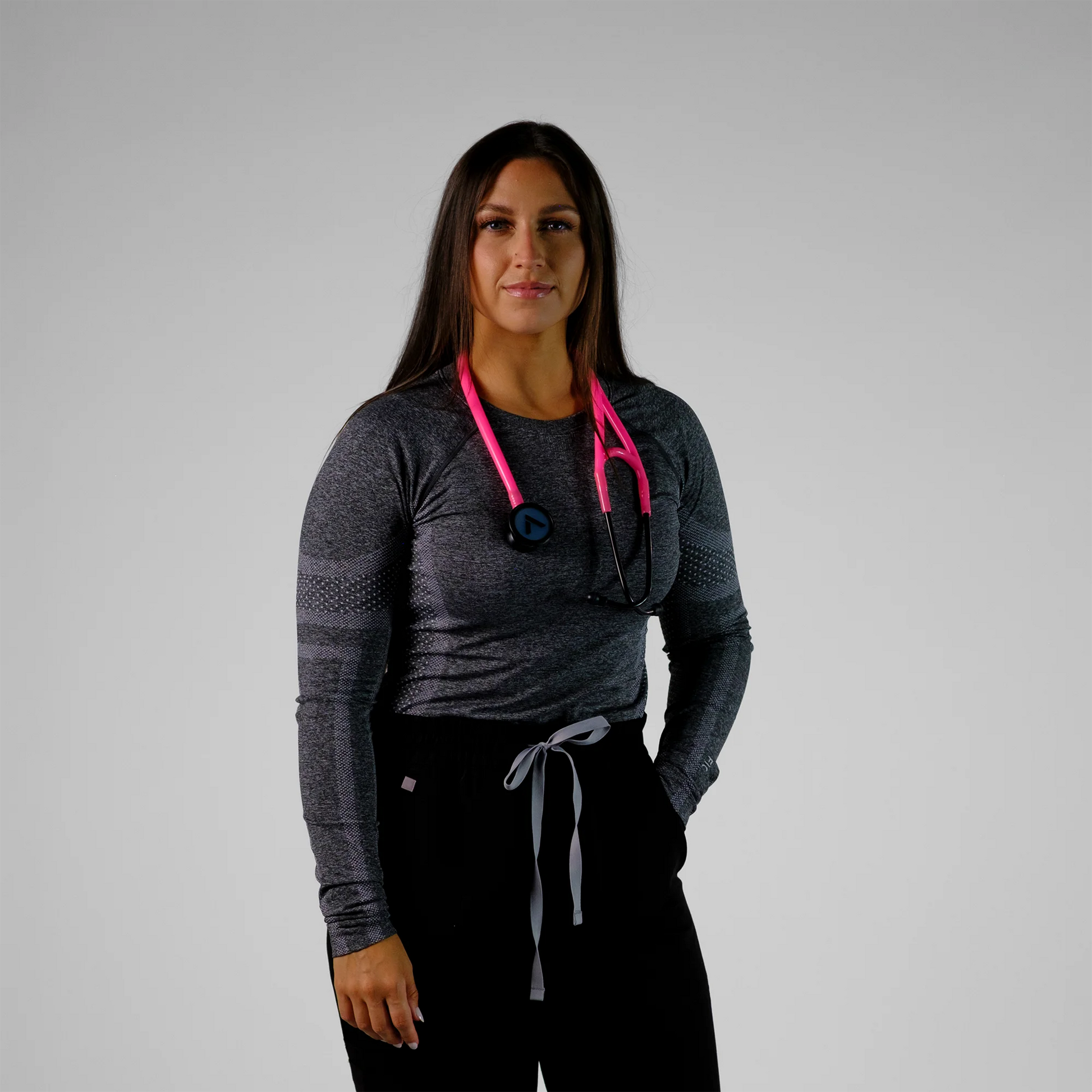 model standing wearing a pink cardiology stethoscope