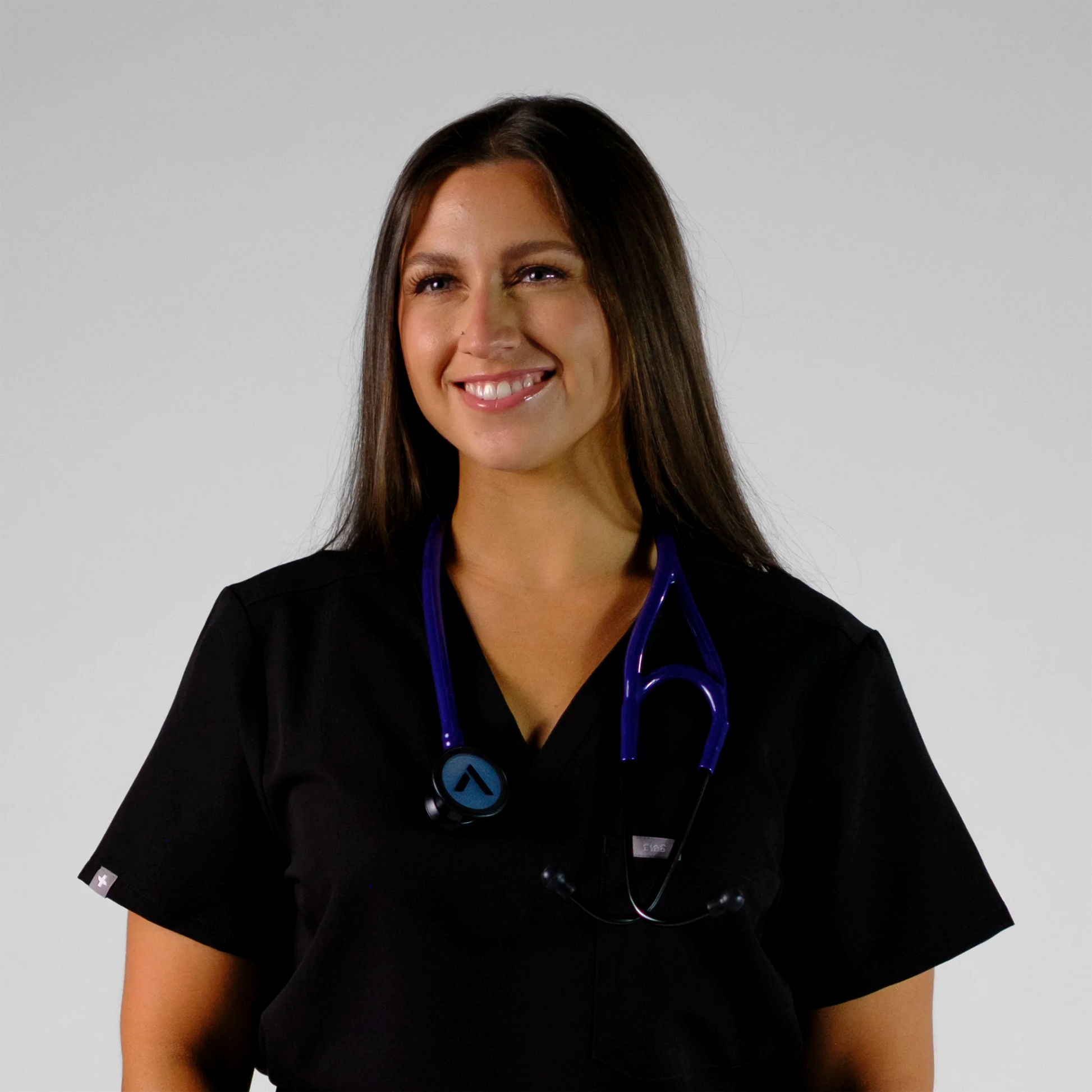 model smiling wearing a purple cardiology stethoscope