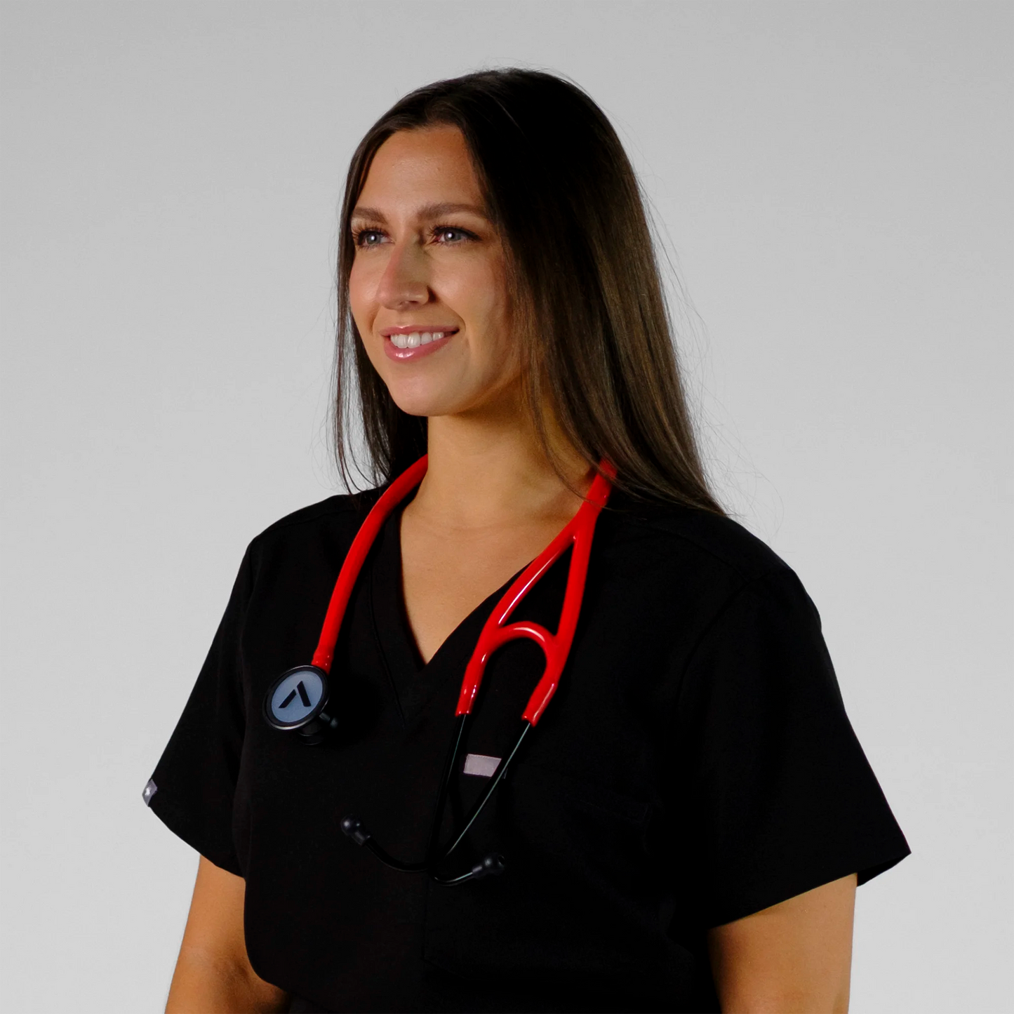 model smiling with a red cardiology stethoscope