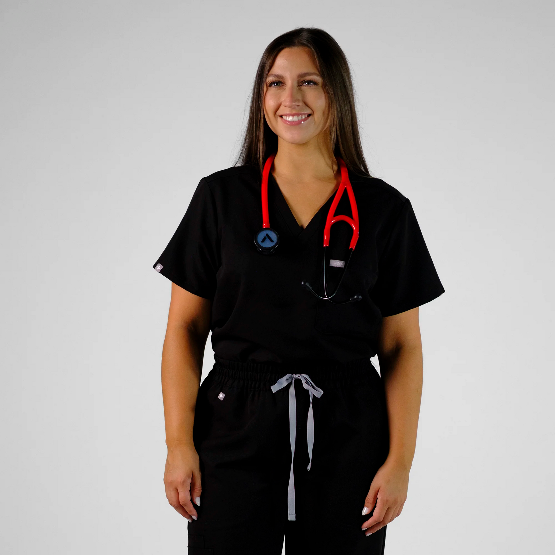 model standing with a red cardiology stethoscope