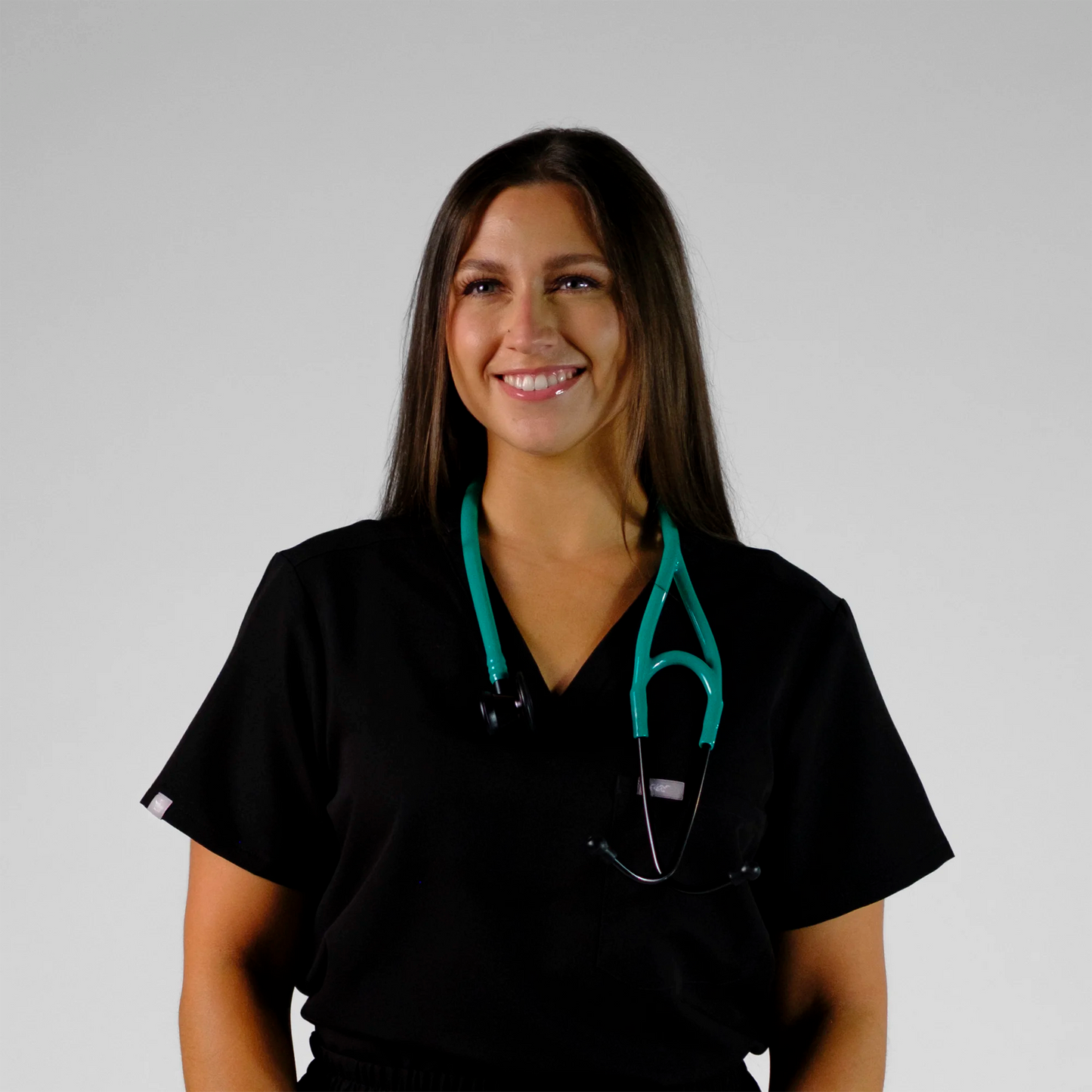 model standing with a teal cardiology stethoscope