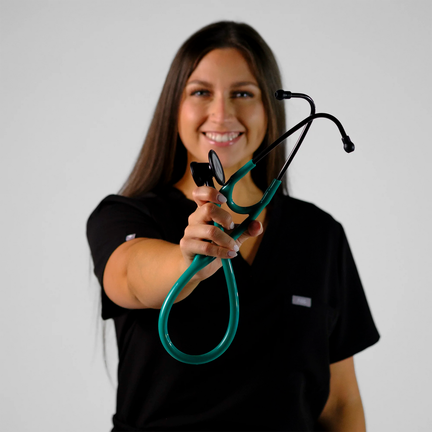 model holding a teal cardiology stethoscope