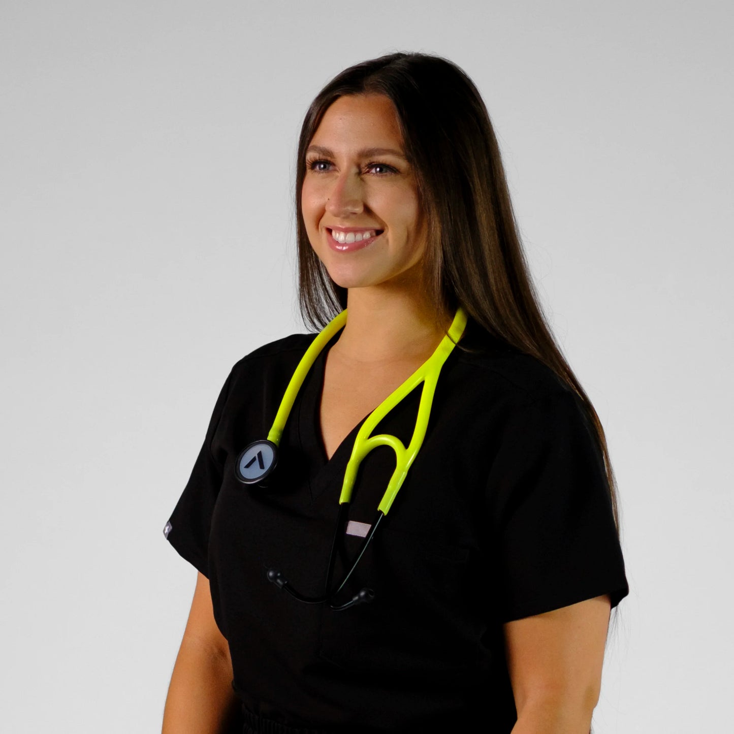 model smiling with a neon yellow cardiology stethoscope