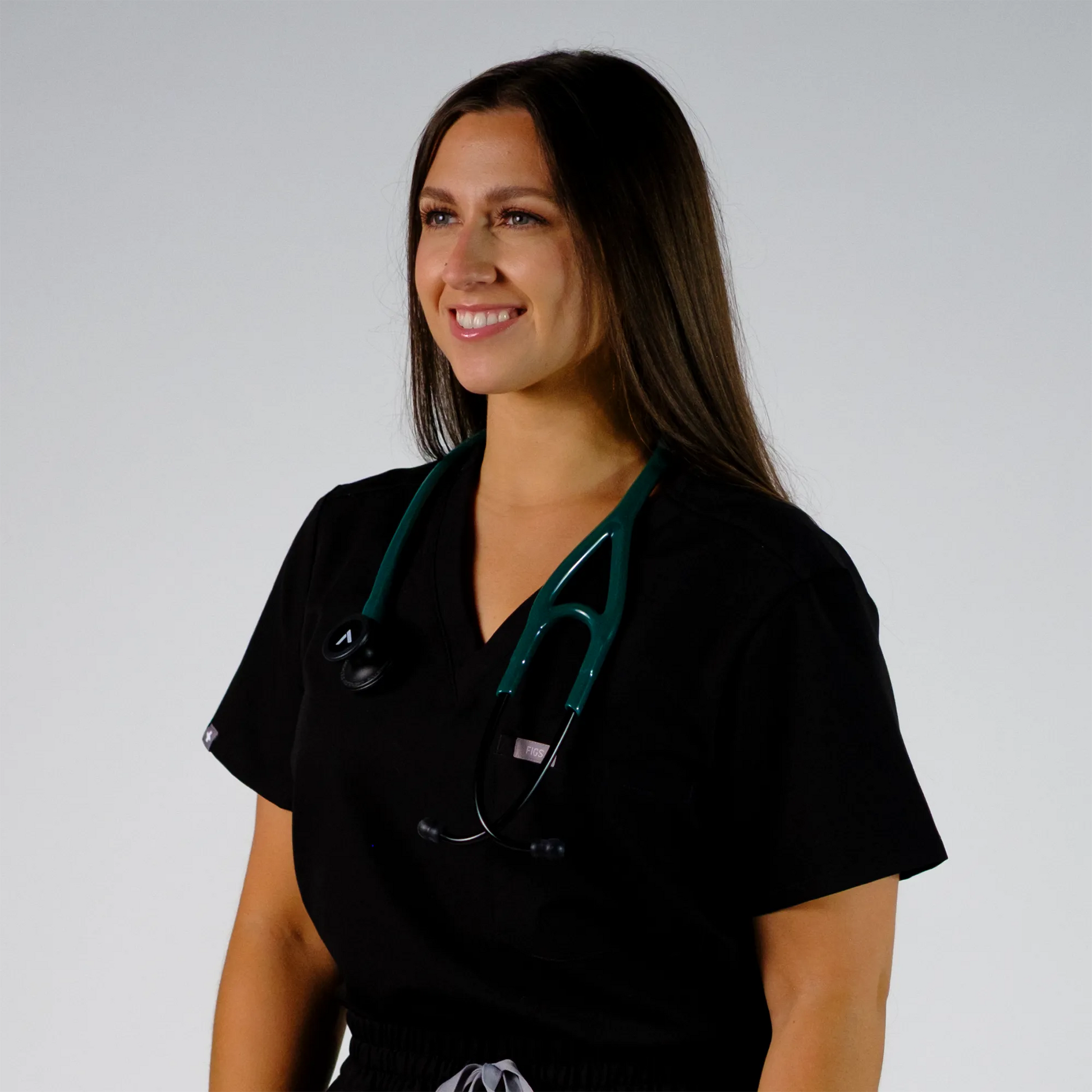 a model smiling with  a teal cardiology stethoscope